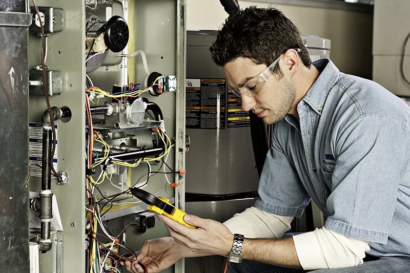 HVAC Technician working on AC unit.